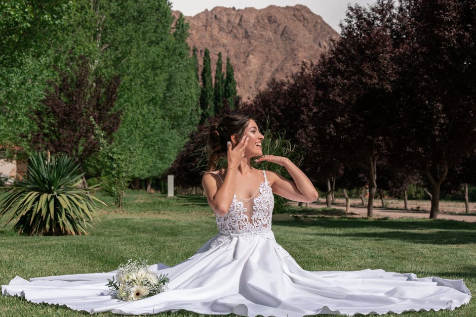 A joyful bride poses elegantly in a beautiful summer garden setting, showcasing her stunning white wedding dress.