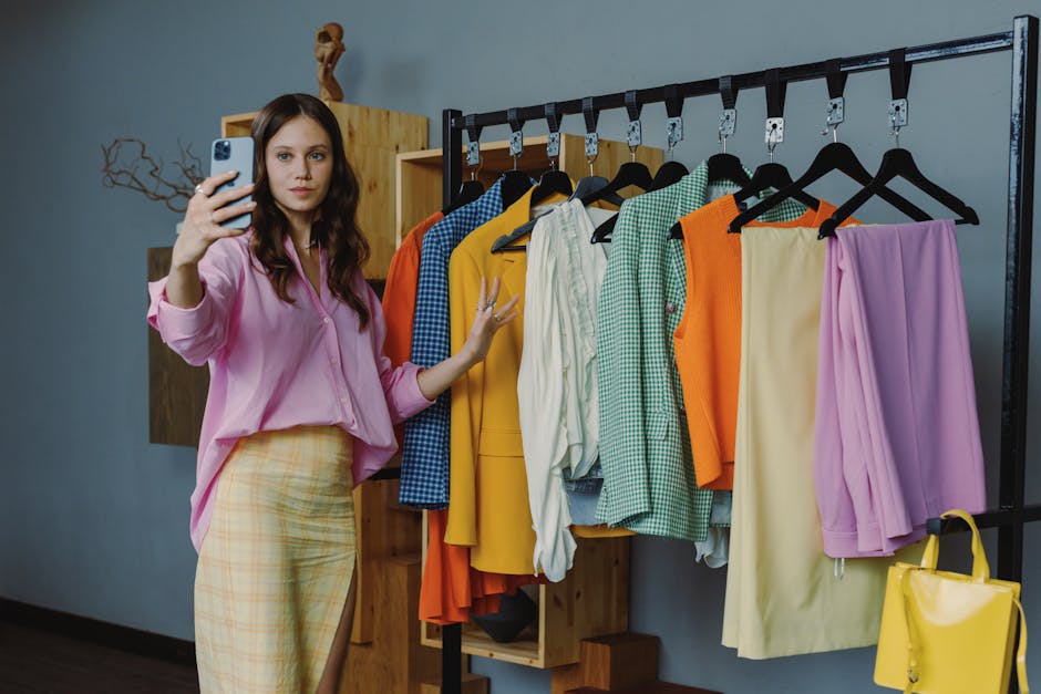 Woman in colorful outfit taking a selfie amidst vibrant clothing options in a modern boutique.